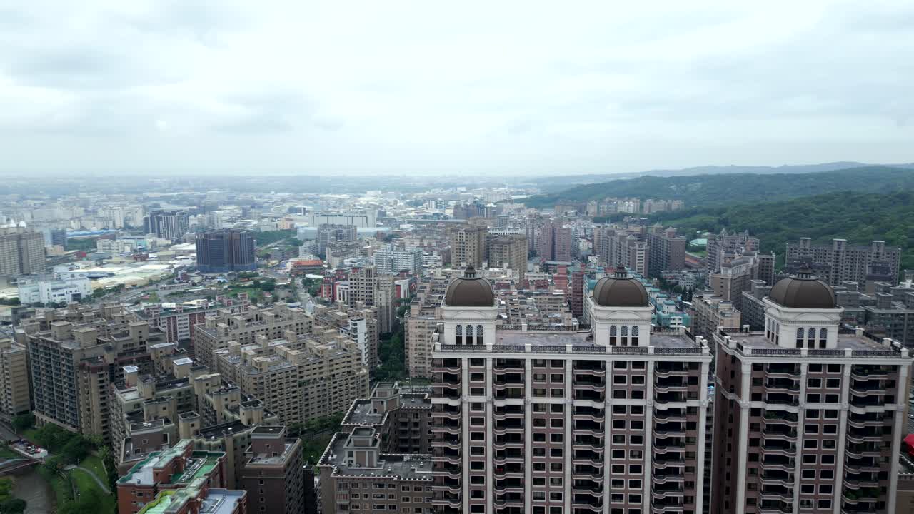 Aerial flyover high-rise buildings with housing area with apartment houses during cloudy day. Luzhu District, Taoyuan City. Wide shot. Rooftop of residential area blocks.