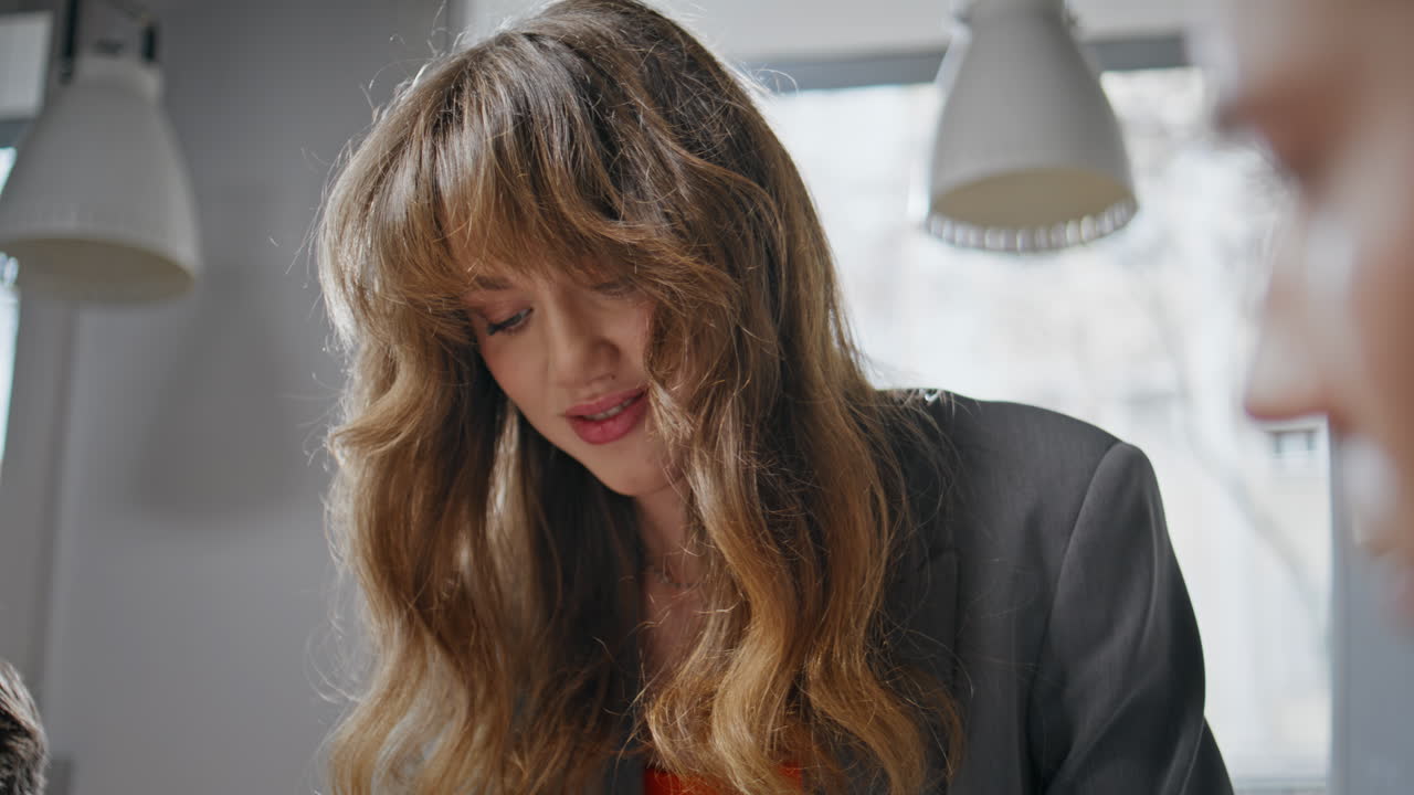 Thoughtful businesswoman listening colleague communicating at workplace closeup