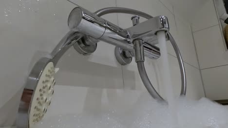 flowing water from tap going into a bathtub.