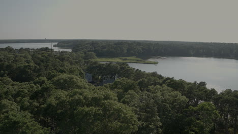 Aerial-pulls-away-from-ponds-in-Cape-Cod-and-tilts-down-to-trees-and-houses