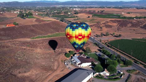 un globo aerostático se eleva sobre el paisaje de la región vinícola de california: imágenes aéreas de drones con movimiento dinámico