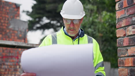 construction worker reviewing plans at a construction site
