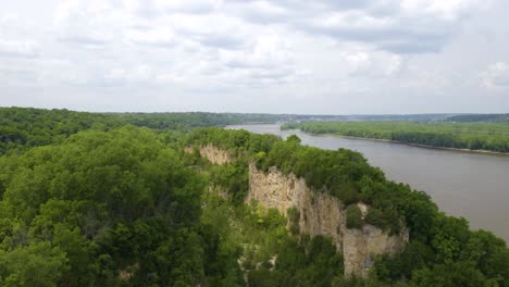 mississippi river revealed behind limestone cliffs at horseshoe bluff hiking trail in iowa