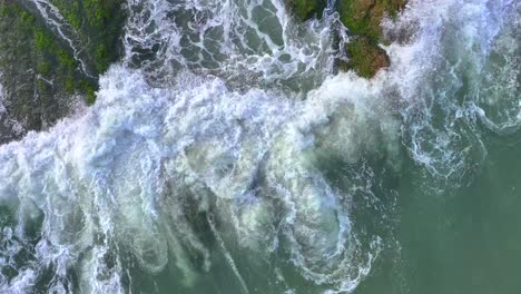 aerial photos of waves hitting reefs and sparking waves