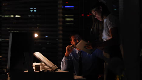 colleagues using a tablet at night