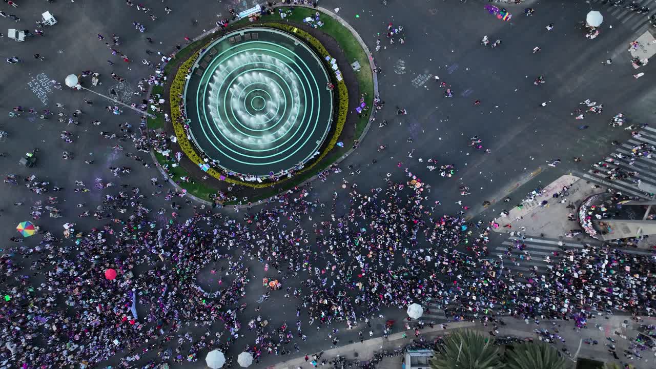 Aerial view above people marching on the streets of Mexico city, during International Women's Day - top down, drone shot