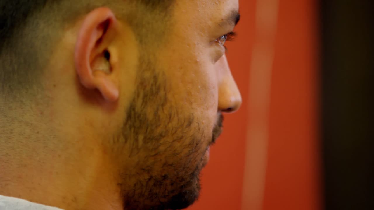 Uomo che si fa spuntare i capelli con il tagliacapelli 4k