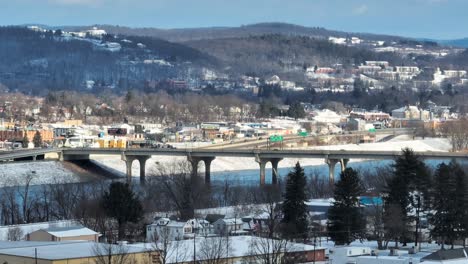 Long-aerial-zoom-of-bridge-over-Susquehanna-river-on-snow-day-in-Williamsport-PA