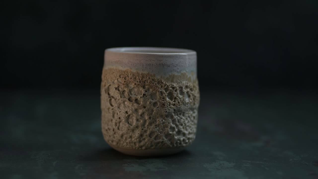 copa de cerámica marrón con textura de volcán rodeada de un poco de humo