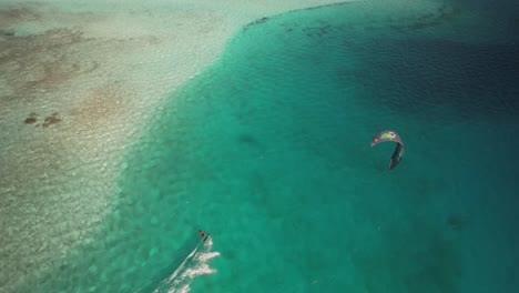 Kitesurfer-Gleitet-über-Türkisfarbenes-Wasser-In-Der-Nähe-Von-Cayo-De-Agua,-Los-Roques,-Ruhe-Von-Oben-Eingefangen