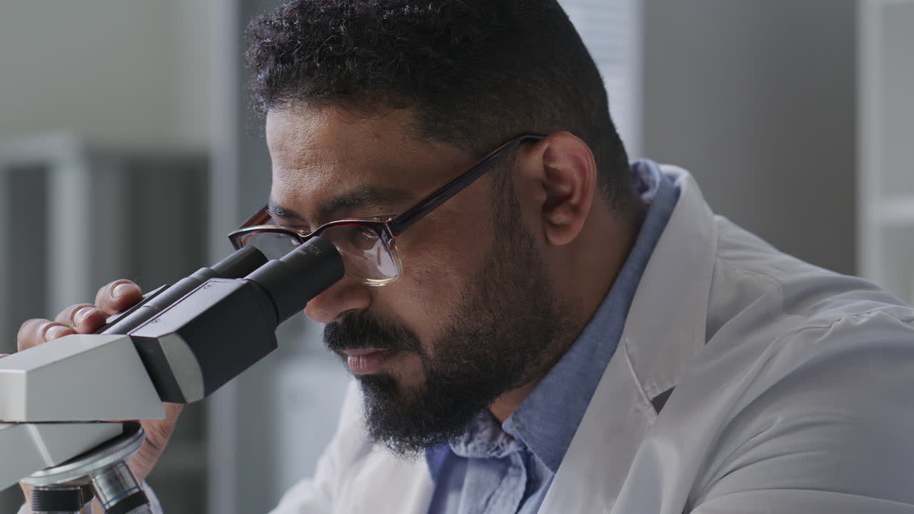 Scientist Using Microscope during Research Work in Laboratory