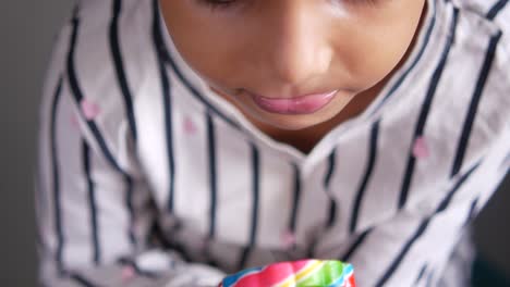 child eating a colorful lollipop