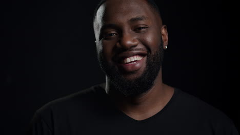 smiling african man looking at camera indoors. afro guy making smile in studio