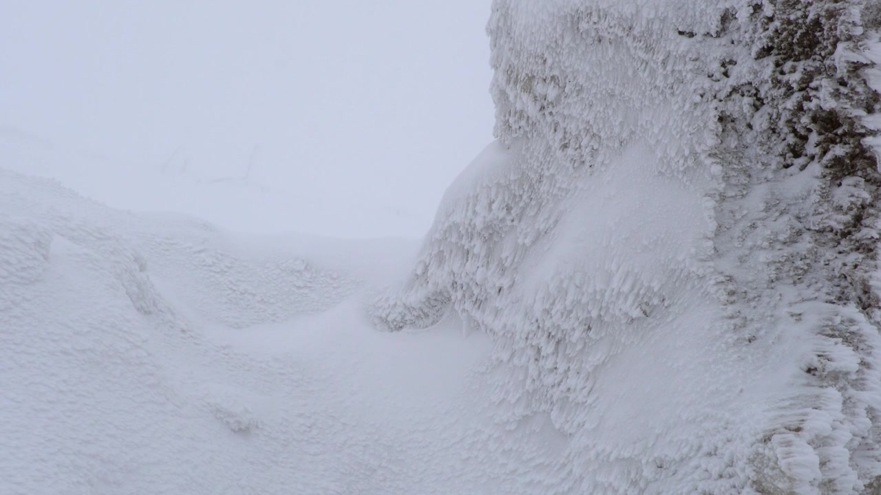 Starker Schneesturm fegt über gefrorene Felslandschaft