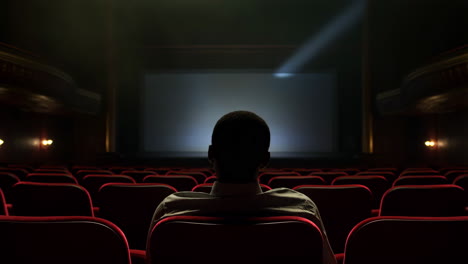 person sitting alone in an empty movie theater