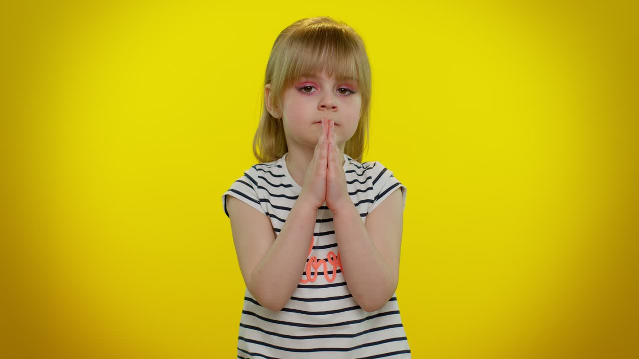Kid child girl praying, making wish, asking with hopeful imploring expression, begging apology