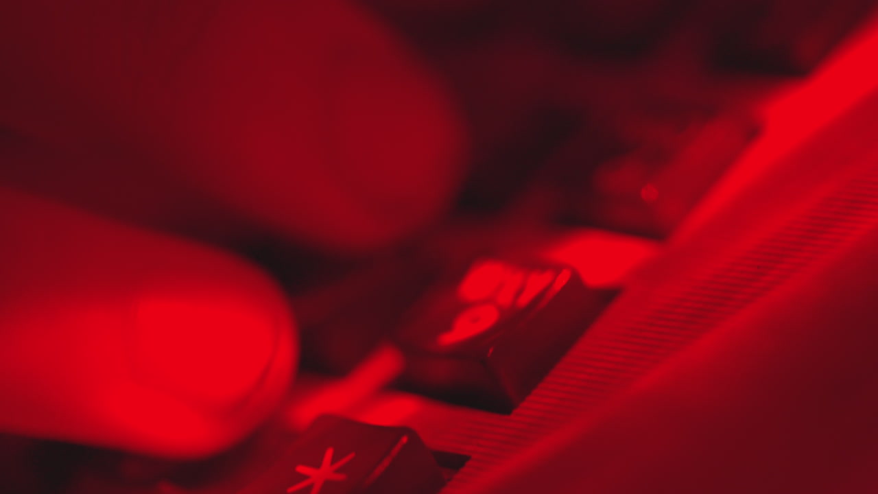 близкий мужской палец набирает телефонный номер, чтобы сделать звонок, красный свет в гостиничном номере