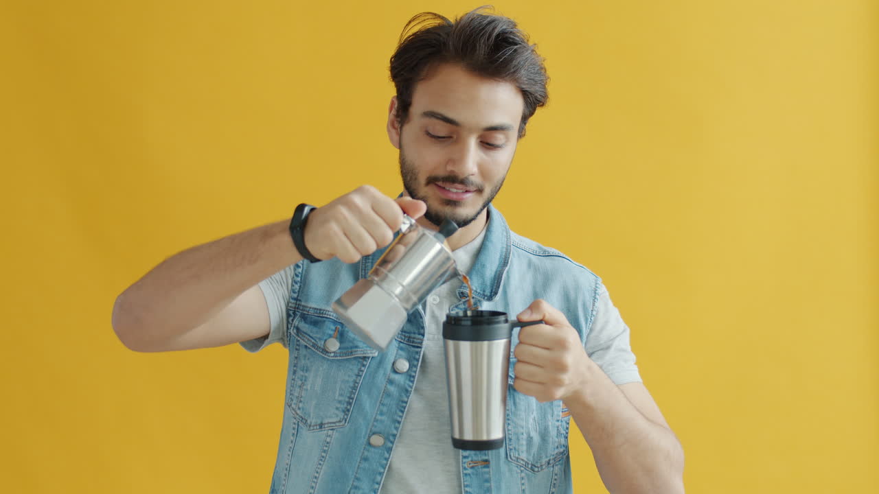 Man pouring coffee from a Moka pot into a travel mug