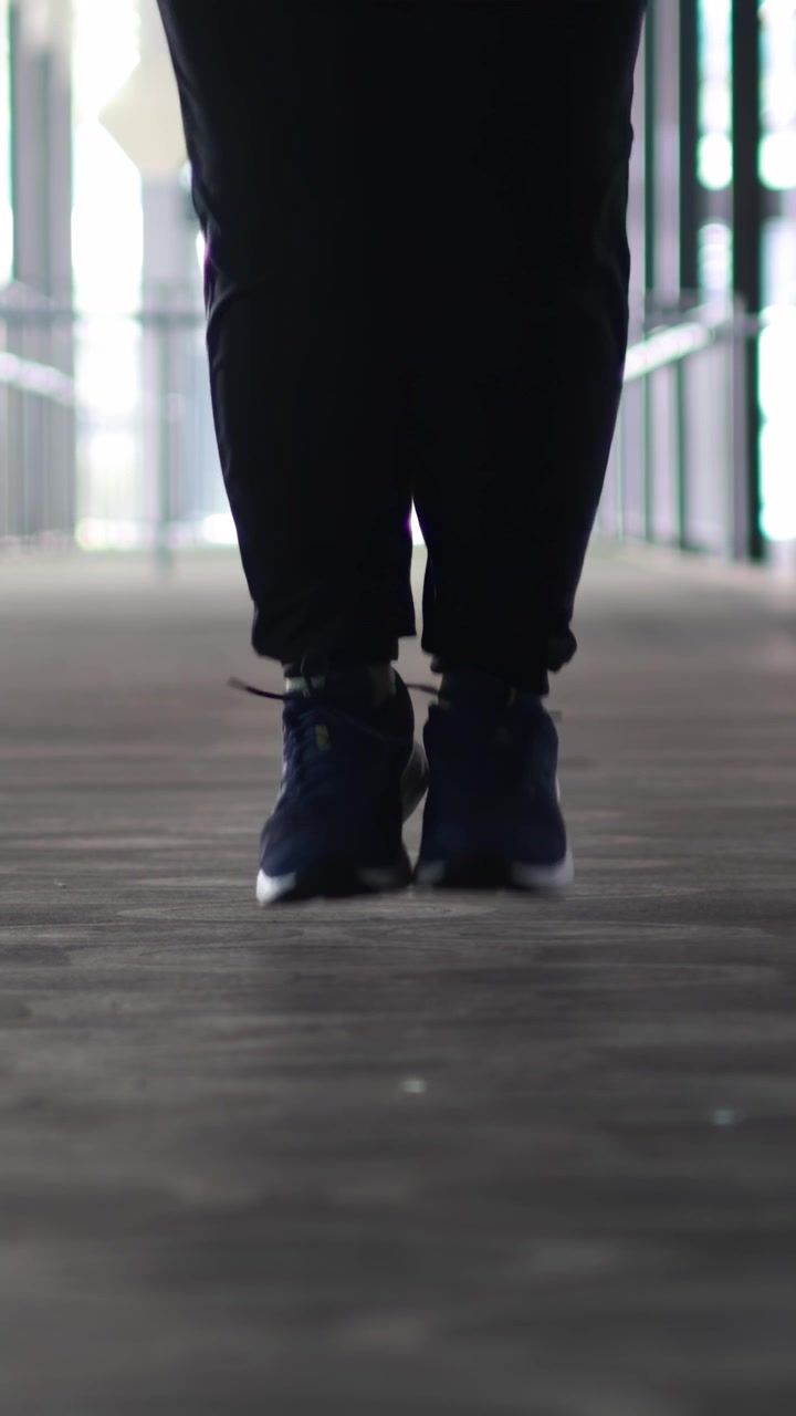 Person performs jump rope exercise in a corridor