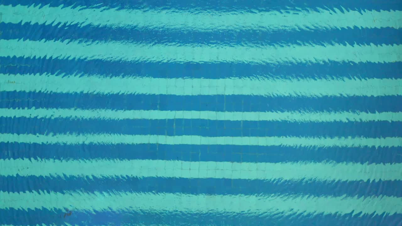 수영장의 공중 상승 공개와 함께 푸른 물에 원형 잔물결