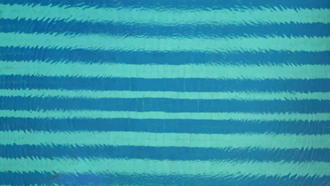 ondas circulares en el agua azul con el aumento aéreo de la piscina