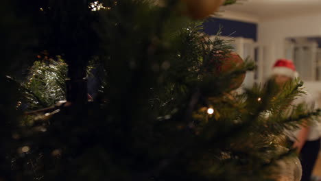 una niña decorando un árbol de navidad