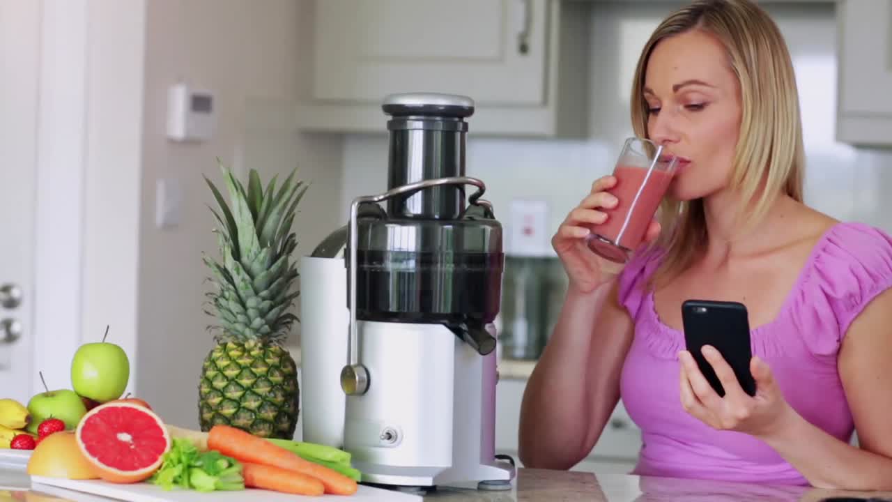 Bionda che beve succo fresco di frutta e verdura