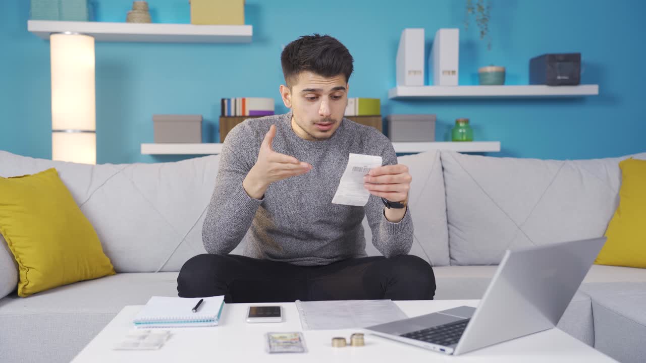 el joven que sufre de facturas altas está estresado e infeliz.