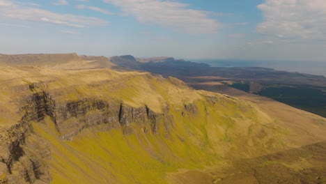 aerial drone footage of the dramatic mountain landscapes on the isle of skye, scotland. sweeping panoramic views of majestic peaks, green valleys, and wild nature. old man of storr