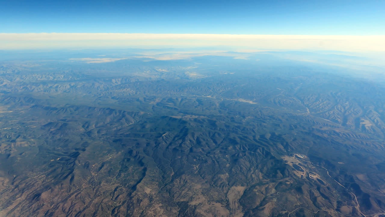 Flying Over Mountainous Terrain, Clear Sky, Blue Atmosphere