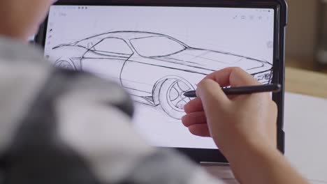 close up of male's hands drawing new car concept on a tablet on the table in the studio