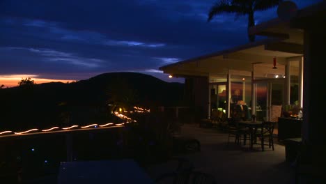 panning shot of the deck of a hillside home at twilight