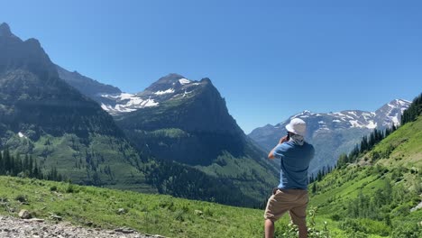 person looking and photographing mountains in glacier national park