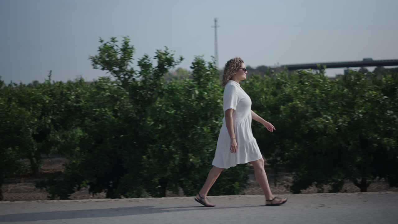 Woman walking in an orange grove