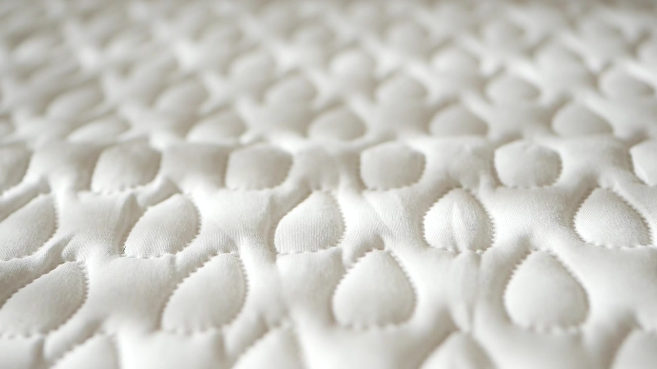 Close-up of White Quilted Mattress Fabric Texture