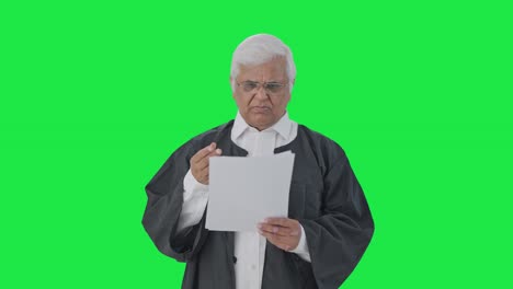 abogado senior indio confundido leyendo documentos de casos judiciales pantalla verde