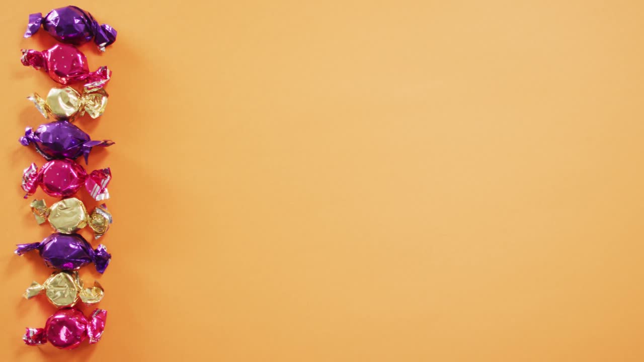 acercamiento de varios dulces de halloween con espacio de copia contra un fondo naranja