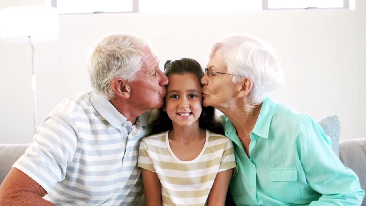 할아버지와 할머니가 손녀에게 키스하고 있습니다.