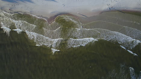 vista aérea de pájaro sobre las olas rompiendo suavemente