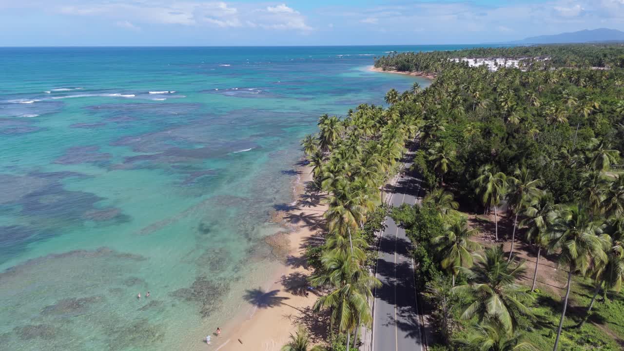 Strada lungo la costa di LAS TERRENAS, SAMANA, Repubblica Dominicana. Ripresa aerea a volo d'uccello. Paesaggio tropicale della spiaggia di Playa el Portillo in estate. Campo lungo.