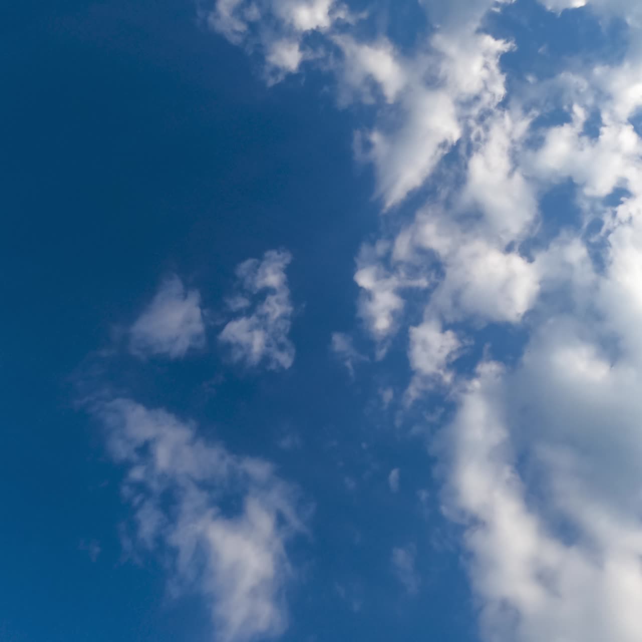 Sun shining brightly on the fluffy white clouds. Wonderful timelapse of soft airy clouds building in the sky