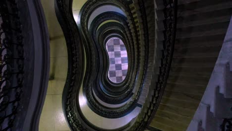 Ascendiendo-Por-Escaleras-De-Caracol-En-Un-Edificio-Art-Deco-En-Brasil,-Antena-Arriba-Hacia-Abajo