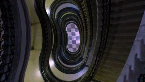 subiendo por las escaleras de espiral en un edificio art deco en brasil, desde el aire hacia abajo