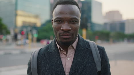 portrait of attractive young african american businessman looking serious intense at camera on urban city sidewalk