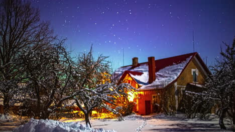 un paisaje navideño invernal con una casa nevada y un jardín bajo un cielo estrellado claro