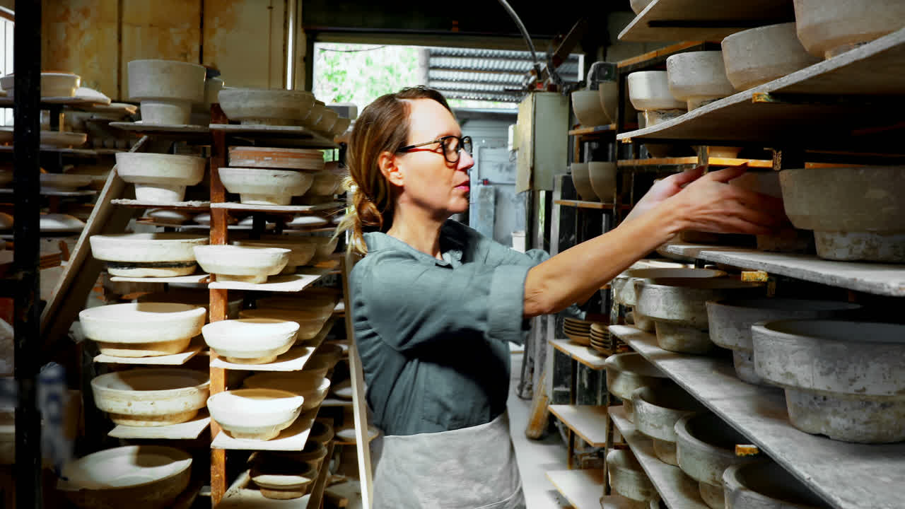 mujer alfarera colocando el cuenco en el estante 4k