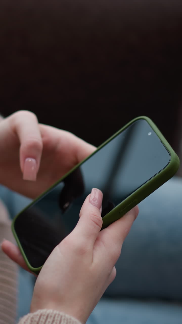 primer plano de una mujer sentada en un centro comercial moderno, sosteniendo un teléfono que muestra una imagen, enfoque suave en su mano y teléfono, con un ambiente interior acogedor y un fondo borroso del espacio del centro comercial