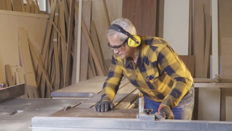 The-carpenter-uses-the-table-saw-and-cuts-the-boards.