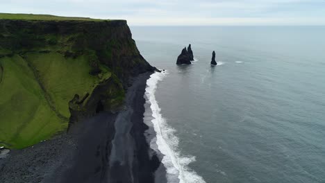 reynisfjara playa de arena negra y pilas de mar sobrevuelo aéreo