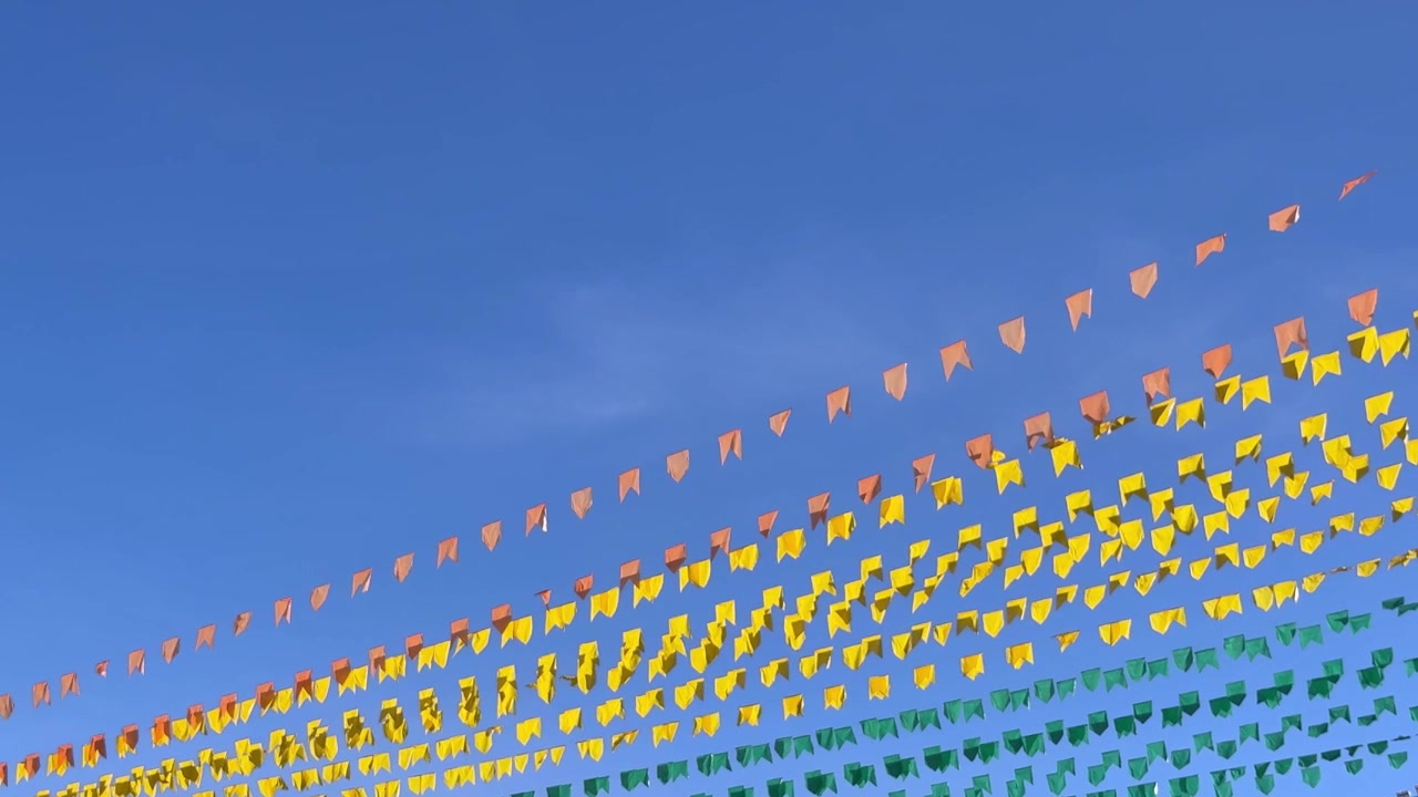 Bandiere colorate che sventolano al vento contro un cielo blu